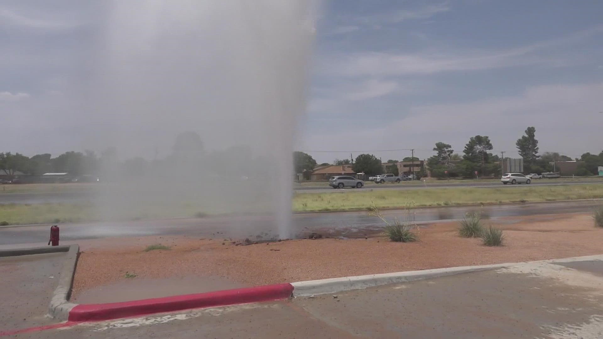 Water and pressure caused a large hole in the ground leading to water spewing into the air.