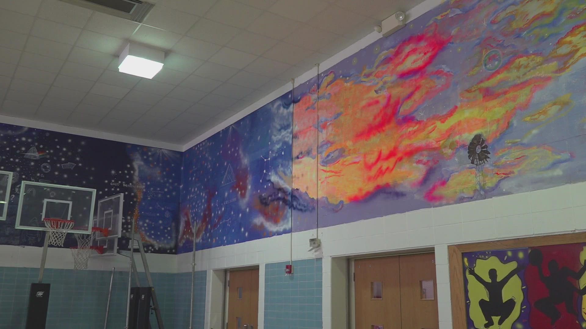 The mural was painted by local artist Tabata Ayup, and it wraps around the cafeteria.
