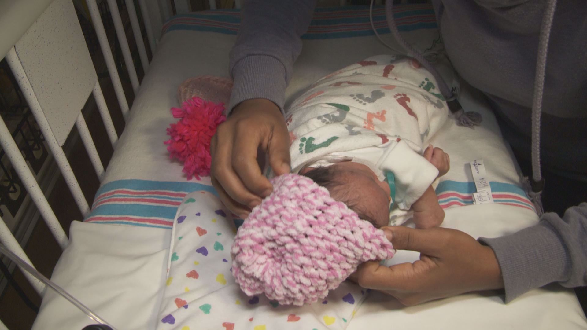 Middle and high school students deliver tiny knit hats for babies